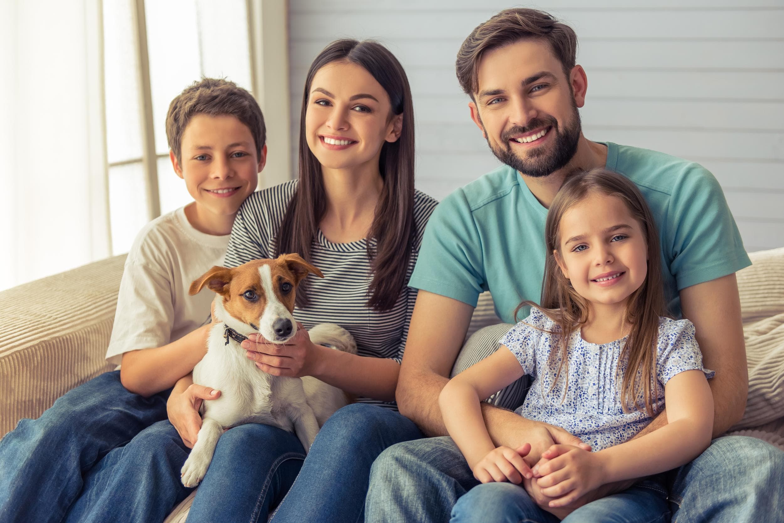 A happy family with their dog at home, protected by safer Zero Bugs pest control